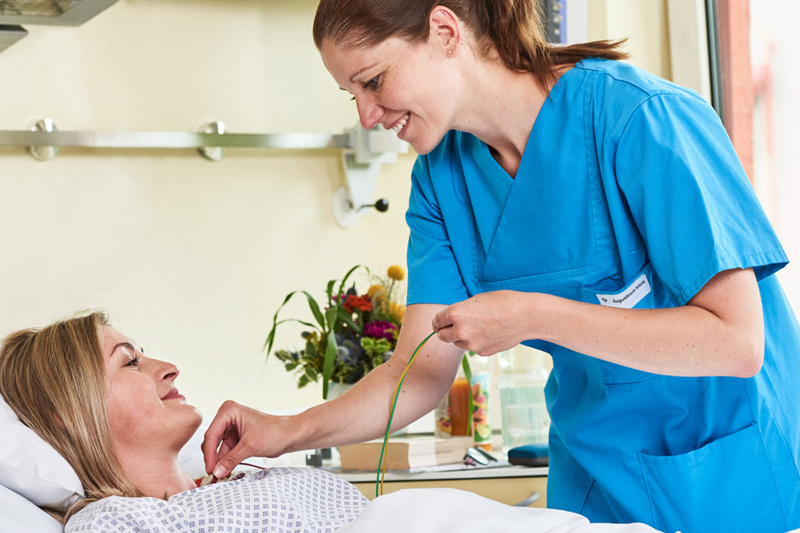 Augustinum Klinik Gastroenterologie Eine Mitarbeiterin der Augustinum Klinik versorgt einer Patientin