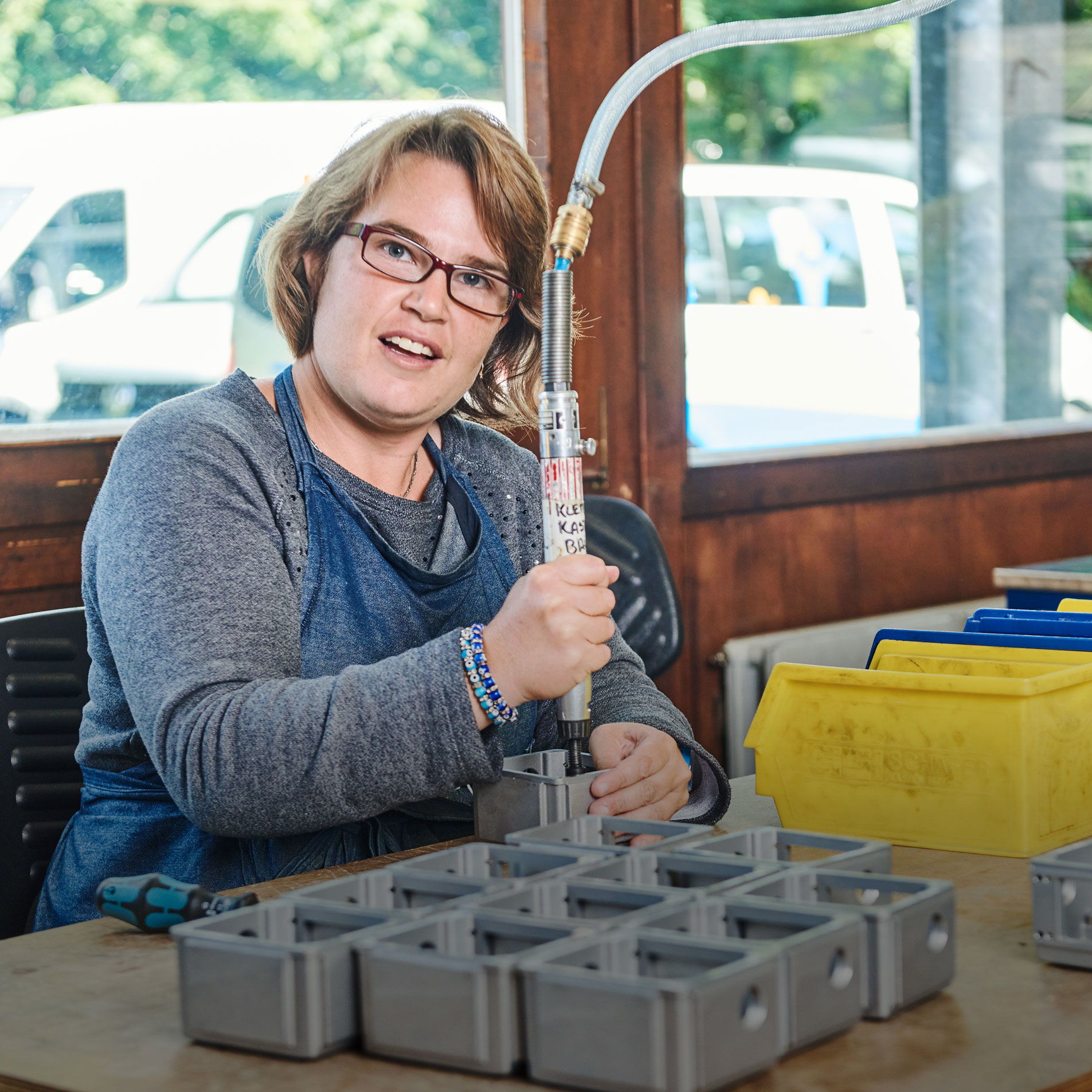 Augustinum Werkstätten Eine Frau arbeitet in einem Metallverarbeitungsraum