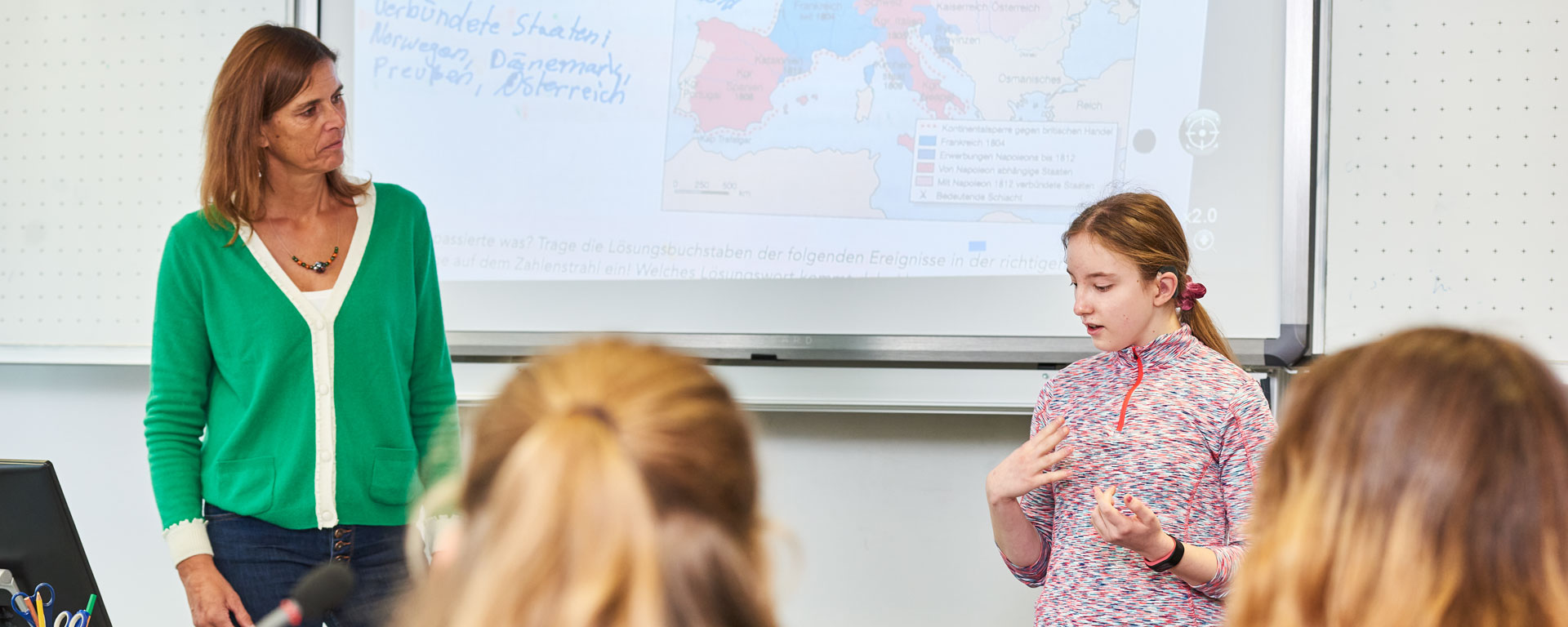 Eine Schülerin der Samuel-Heinicke-Realschule erklärt vor der Klasse etwas in Gebärdensprache