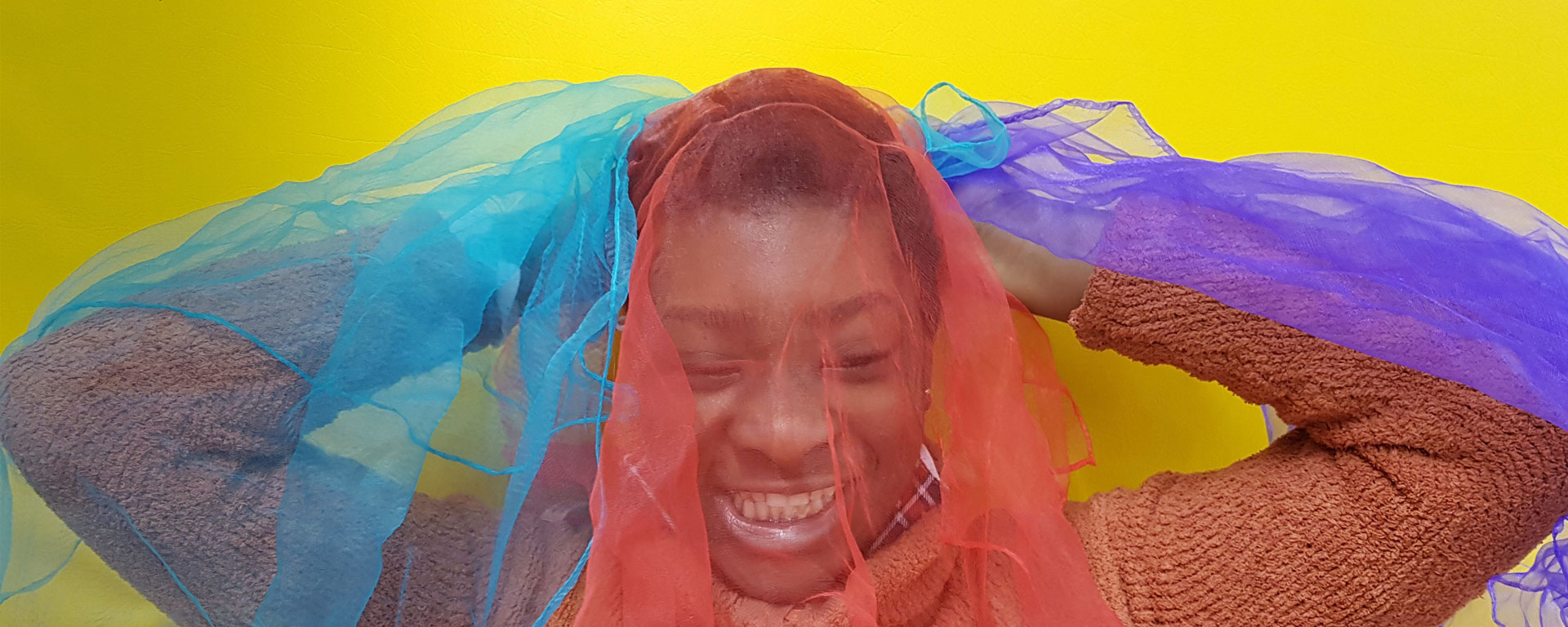 Augustinum Schulen, Internate und Tagesstätten Ein lächelndes Mädchen mit bunten Tüchern