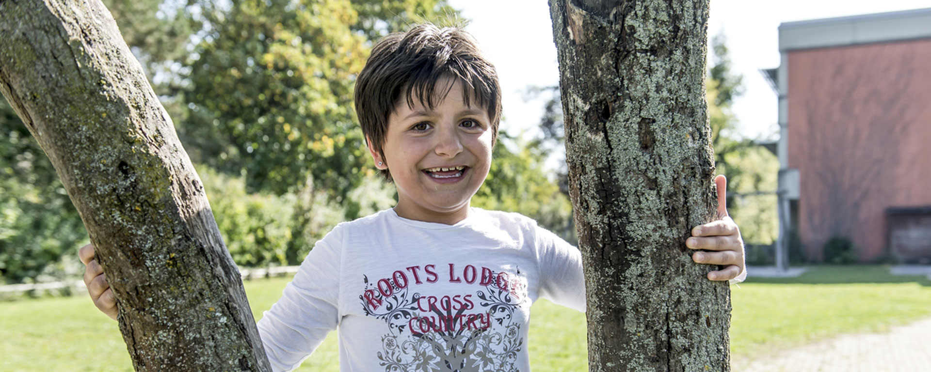 Augustinum Schulen, Internate und Tagesstätten Slider Ein glückliches Kind im Park der Augustinum Tagesstätten