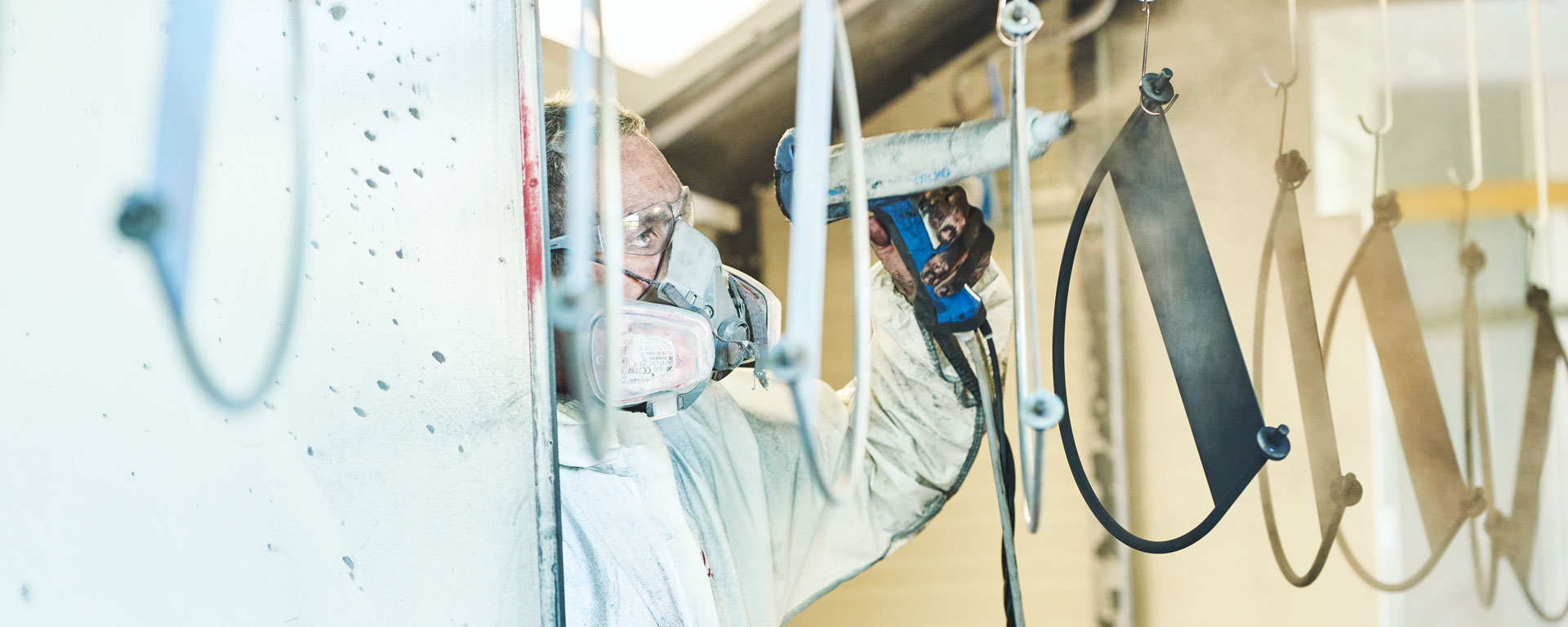 Augustinum Werkstätten Pulverbeschichtung Ein Klient arbeitet im Bereich der Pulverbeschichtung