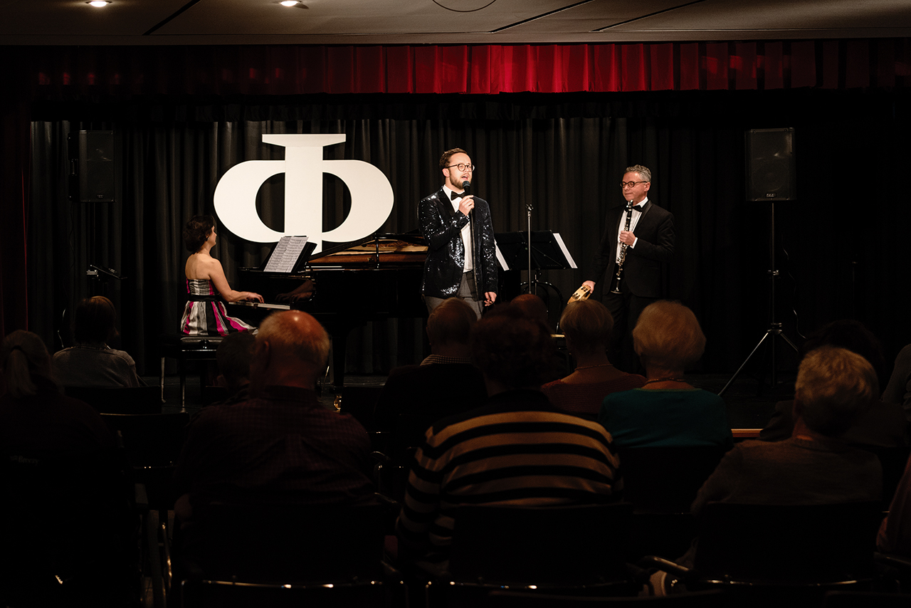 Augustinum Seniorenresidenz Bad Neuenahr Bühne Eine Gruppe bestehend aus einem Sänger, einer Pianistin und einem Klarinettisten stehen auf einer Bühne