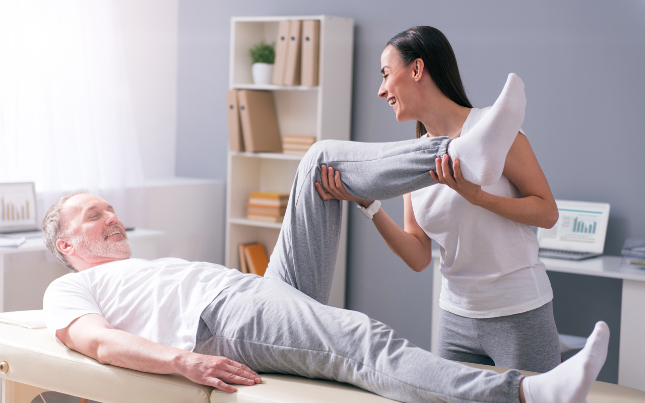 Massagen Eine Physiotherapeutin behandelt einen Patienten