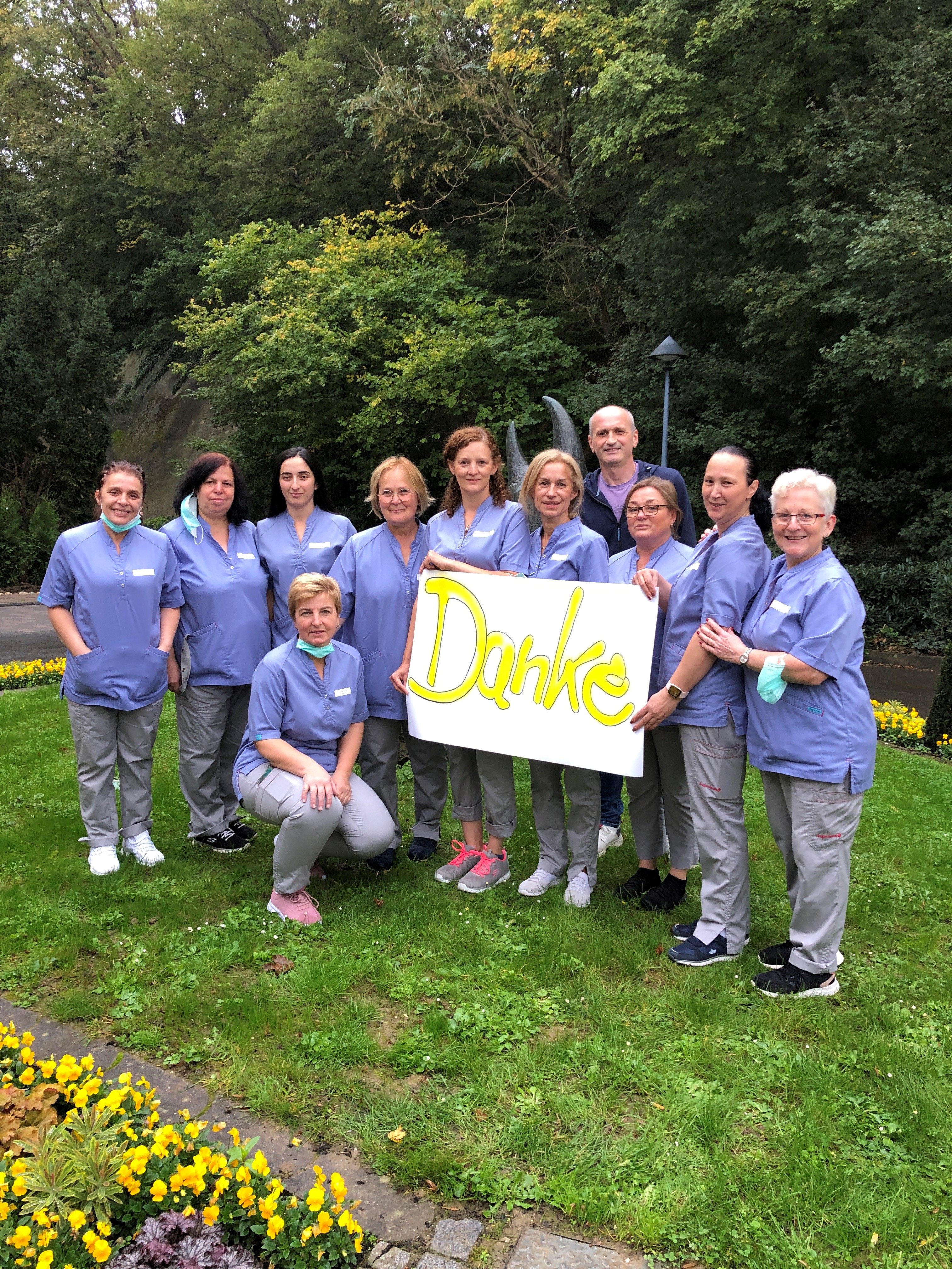 Augustinum Fluthilfe Slider Mitarbeiter*innen der Augustinum Seniorenresidenz Bad Neuenahr halten ein Schild mit der Aufschrift "Danke"