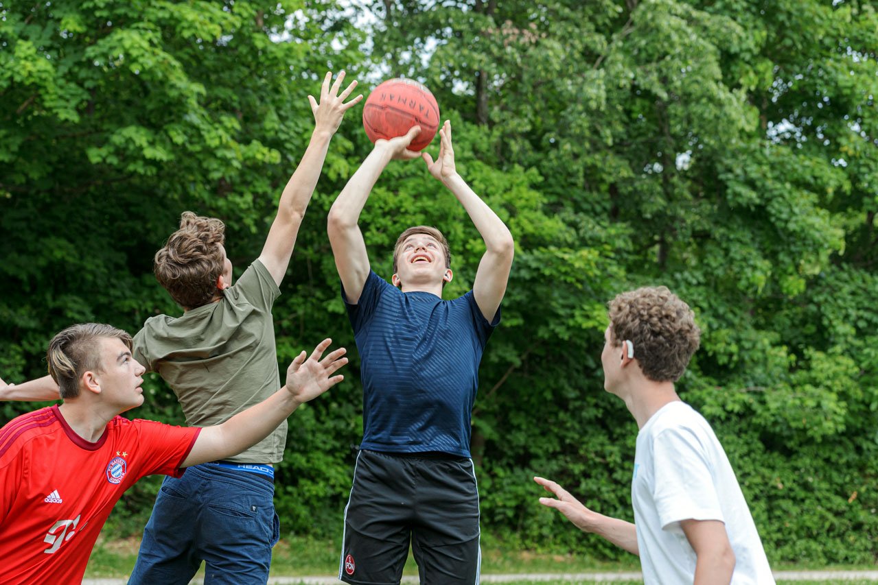 Eine Gruppe Jugendlicher beim Basketballspielen.