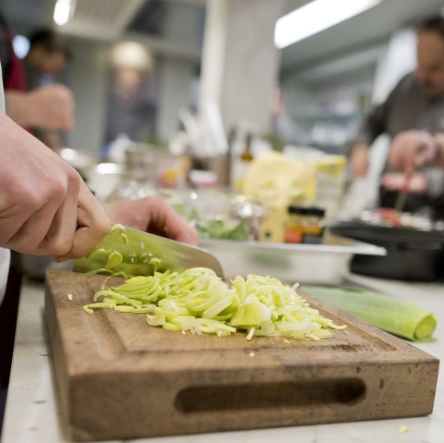 Augustinum Vital Zubereitung Ein Koch schneidet Spitzkohl