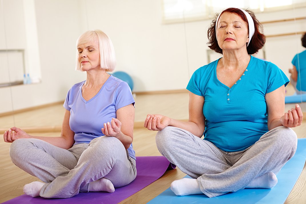 Yoga Zwei Seniorinnen im Schneidersitz