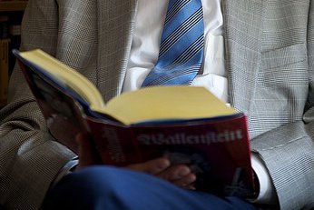 Literaturkreis Aufgeschlagenes Buch auf dem Schoß eines Mannes