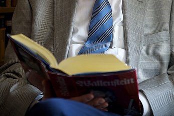 Literaturkreis aufgeschlagenes Buch auf dem Schoß eines Mannes