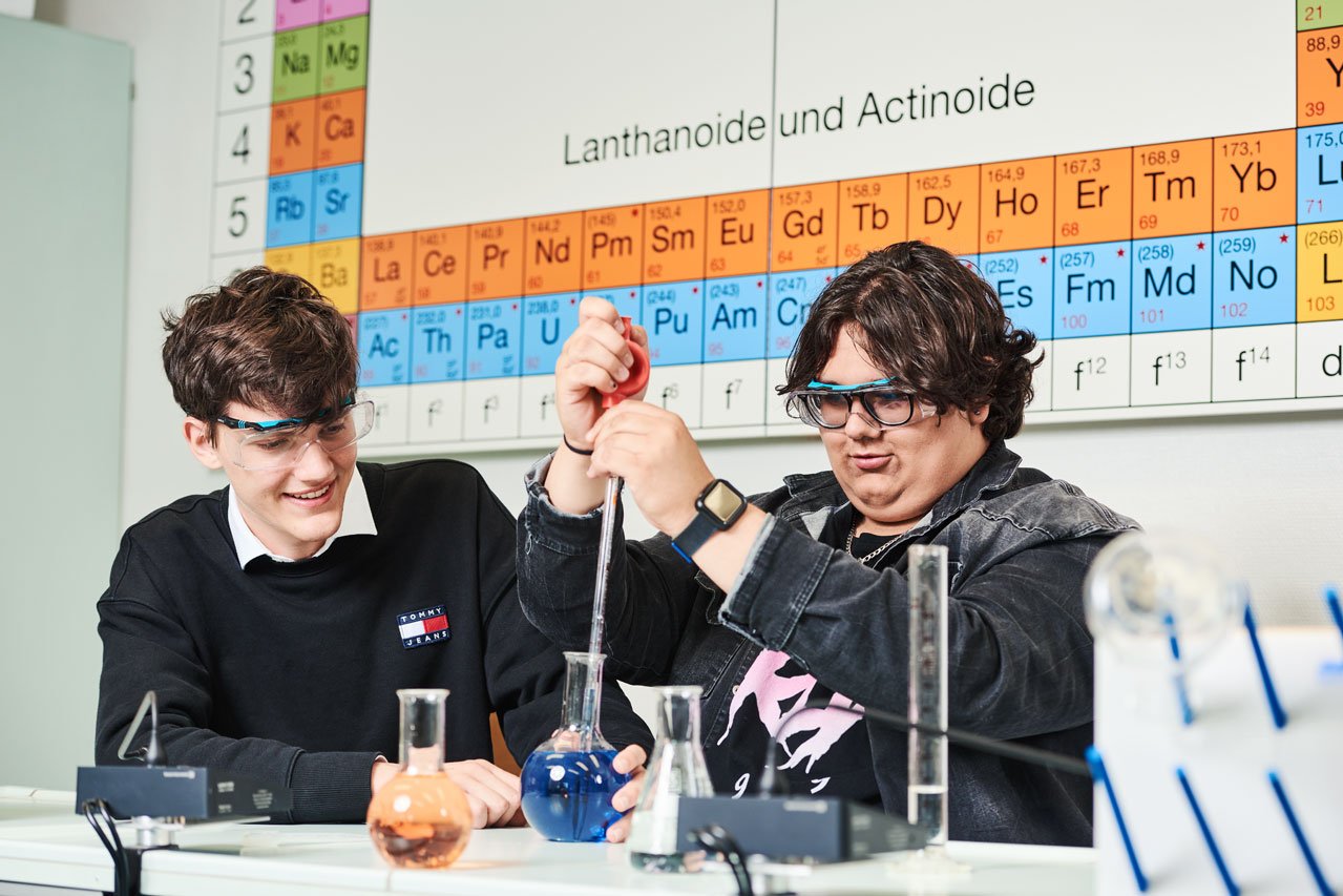 Chemieunterricht Zwei Schüler machen ein Experiment im Chemieunterricht