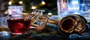 Stimmungsbild mit Trompete, Glühwein & Tannengrün eine Trompete, ein Tannenzweig und ein rotes Getränke
