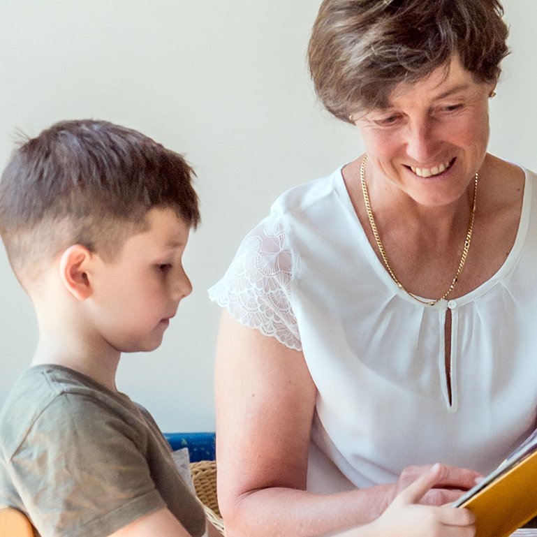 Augustinum Berchtesgadener Land Kindertagesstätte Eine Frau und ein Kind lesen gemeinsam ein Buch