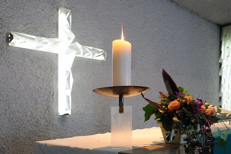 Augustinum Seniorenresidenzen Andachten und Gottesdienste Ein Kreuz, eine Kerze und ein Blumenstrauß