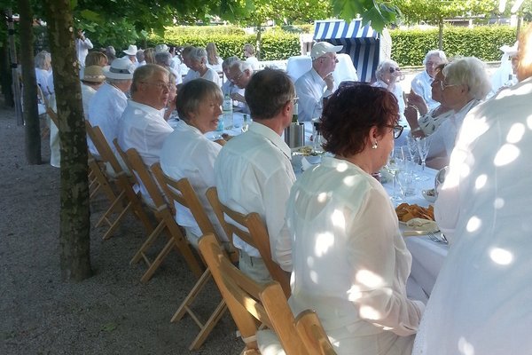 Augustinum Seniorenresidenz Hamburg Feste Senior*innen sitzen gemeinsam an einem großen Tisch