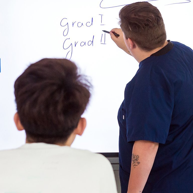 Augustinum Berchtesgadener Land Berufsfachschule Ein Schüler schreibt bei einem Kurs der Berufsfachschule für Pflege etwas an die Tafel
