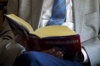 Literaturkreis Aufgeschlagenes Buch auf dem Schoß eines Mannes