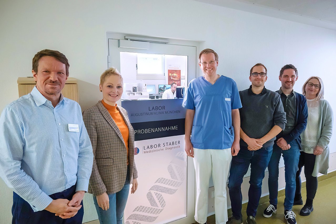 Neues Labor der Dr. Staber GmbH in der Augustinum Klinik Mitarbeiter von Augustinum Klinik und Labor Staber vor der Eingangstür zum neuen Labor