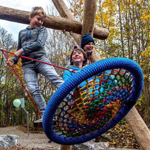 Projekte Kinder schaukeln auf einer Nestschaukel gemeinsam und freuen sich. Auf einem Schriftzug steht Spendenrbericht 2021
