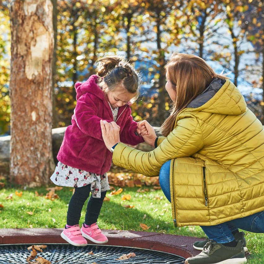 Dauerspende Eine Frau und ein Kind spielen im Freien