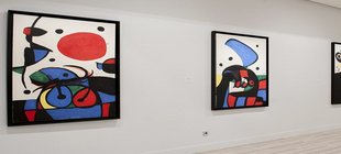 Joan Miró und die Heiterkeit der Träume Vier farbenfrohe Bilder des Surrealismus von Joan Miro an einer Wand
