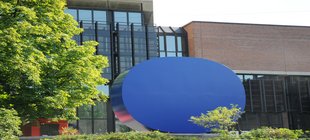 Blaue Scheiben-Skulptur vor einem Gebäude Blaue Scheiben-Skulptur vor einem Gebäude