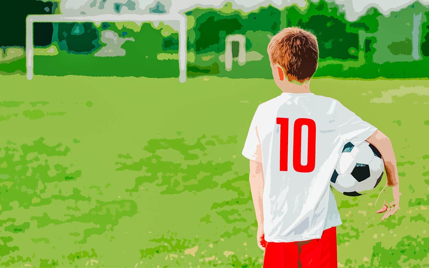 Rückenansicht eines Jungen mit Trikot und Ball unter dem Arm, der auf ein leeres Spielfeld schaut