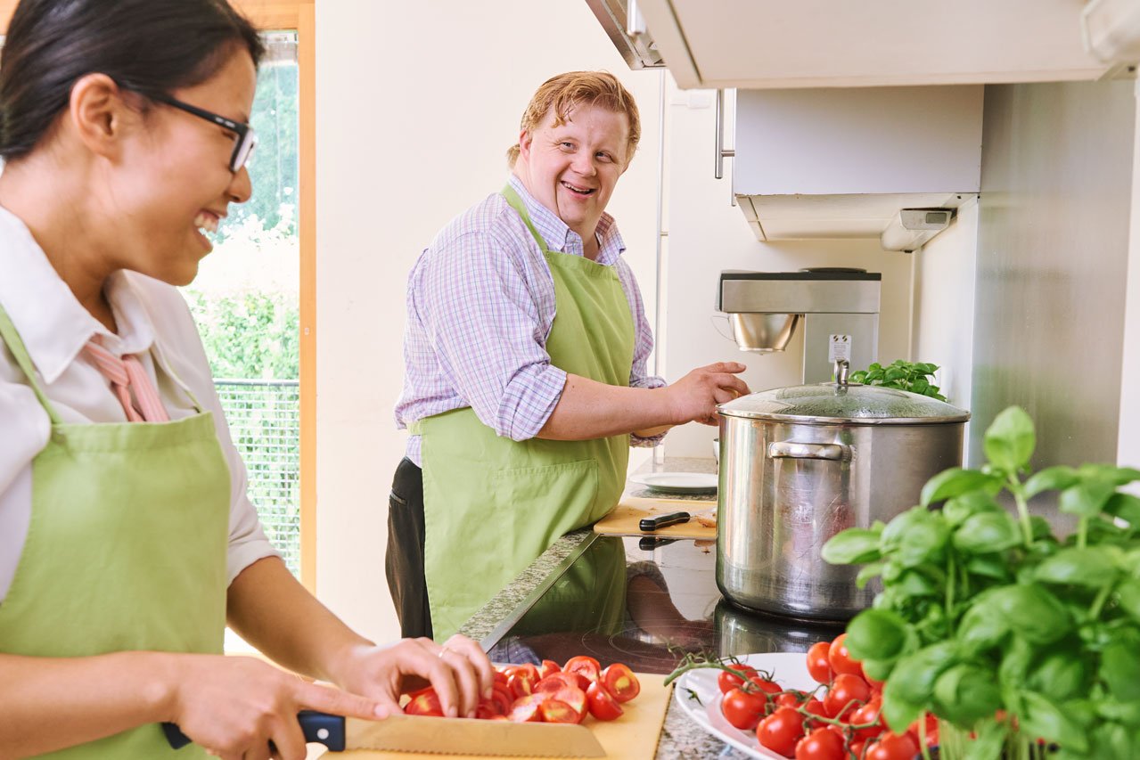 Gemeinsames Kochen Ein Bewohner und eine Mitarbeiterin kochen gemeinsam