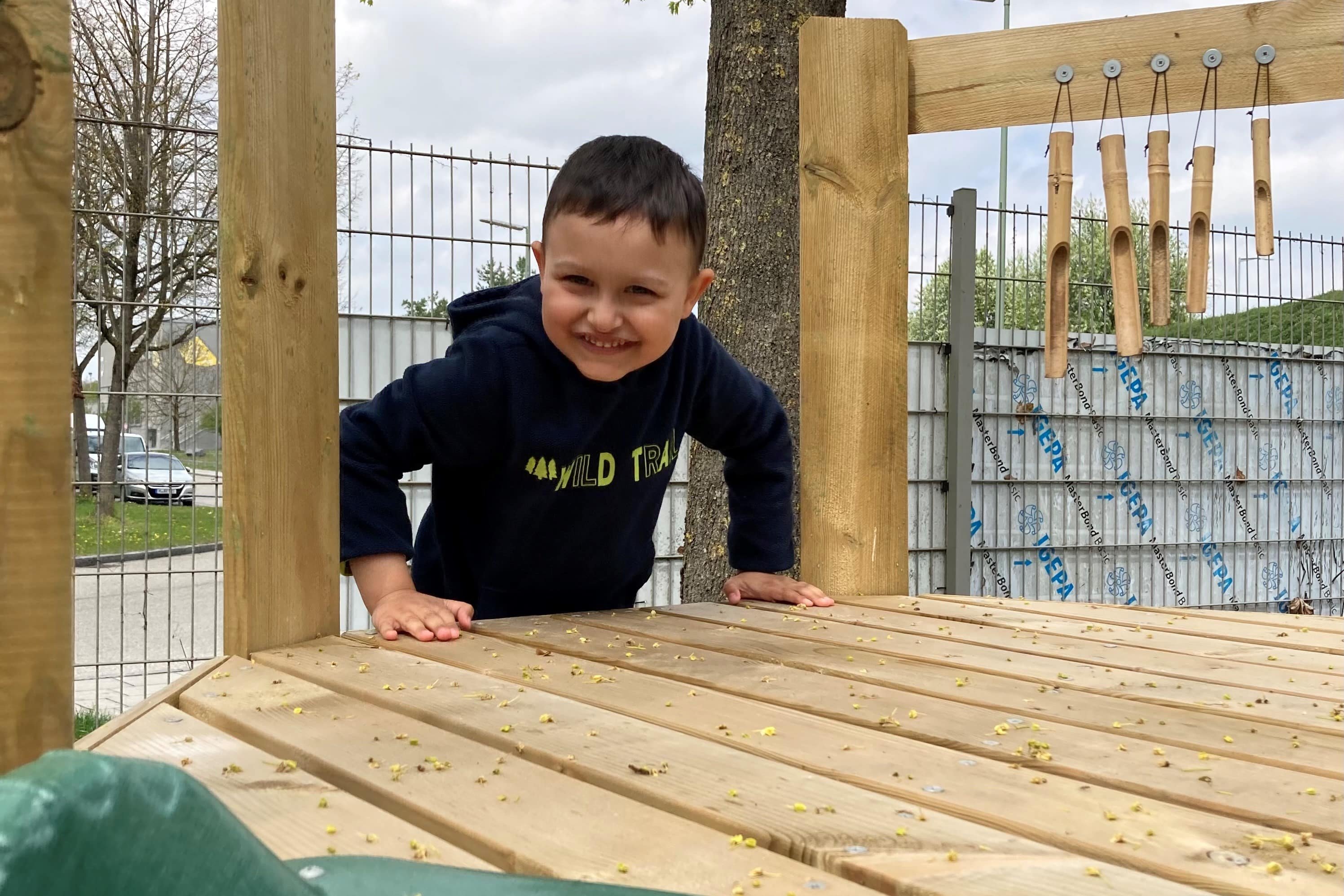 Augustinum Frühförderstellen Gartenbereich Ein Kind klettert im Gartenbereich einer Frühförderstelle des Augustinum