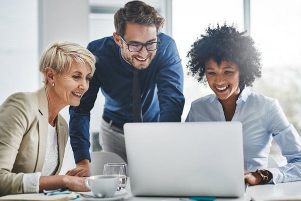 Augustinum Kontakt Kolleg*innen schauen gemeinsam auf einen Laptop