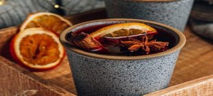 Glühweinbecher mit Zitrusfrüchten und Gewürzen