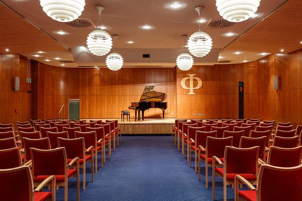 Theaterbühne Stühle vor einer Bühne, auf der ein Flügel steht