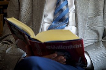 Literatur Aufgeschlagenes Buch auf dem Schoß eines Mannes