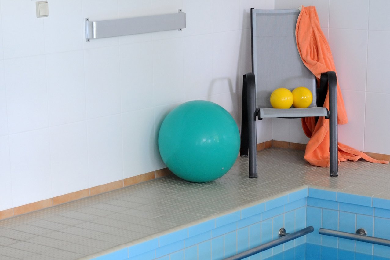 Schwimmen und Wassergymnastik Gymnastikbälle am Rand eines Schwimmbeckens