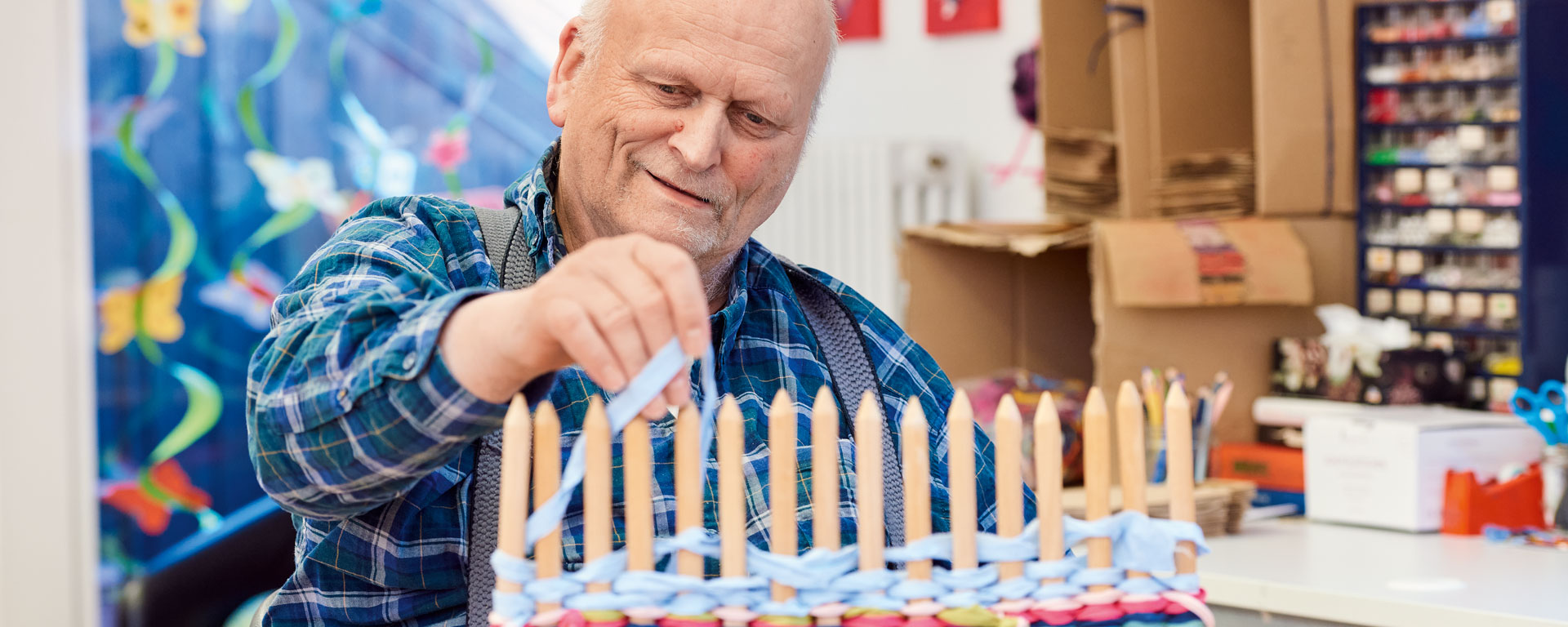 Aktivierung der grob- und feinmotorischen Fähigkeiten Ein Klient mit einem Stäbchen-Webrahmen