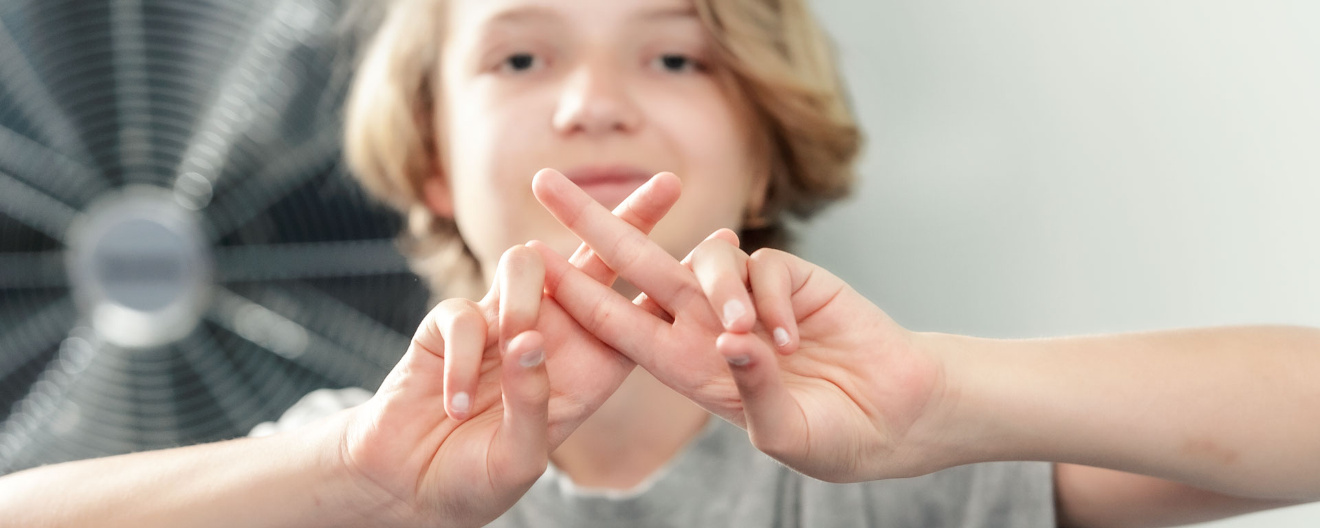 Augustinum Pädagogische Einrichtungen Slider Ein Junge legt zwei Finger beider Hände übereinander