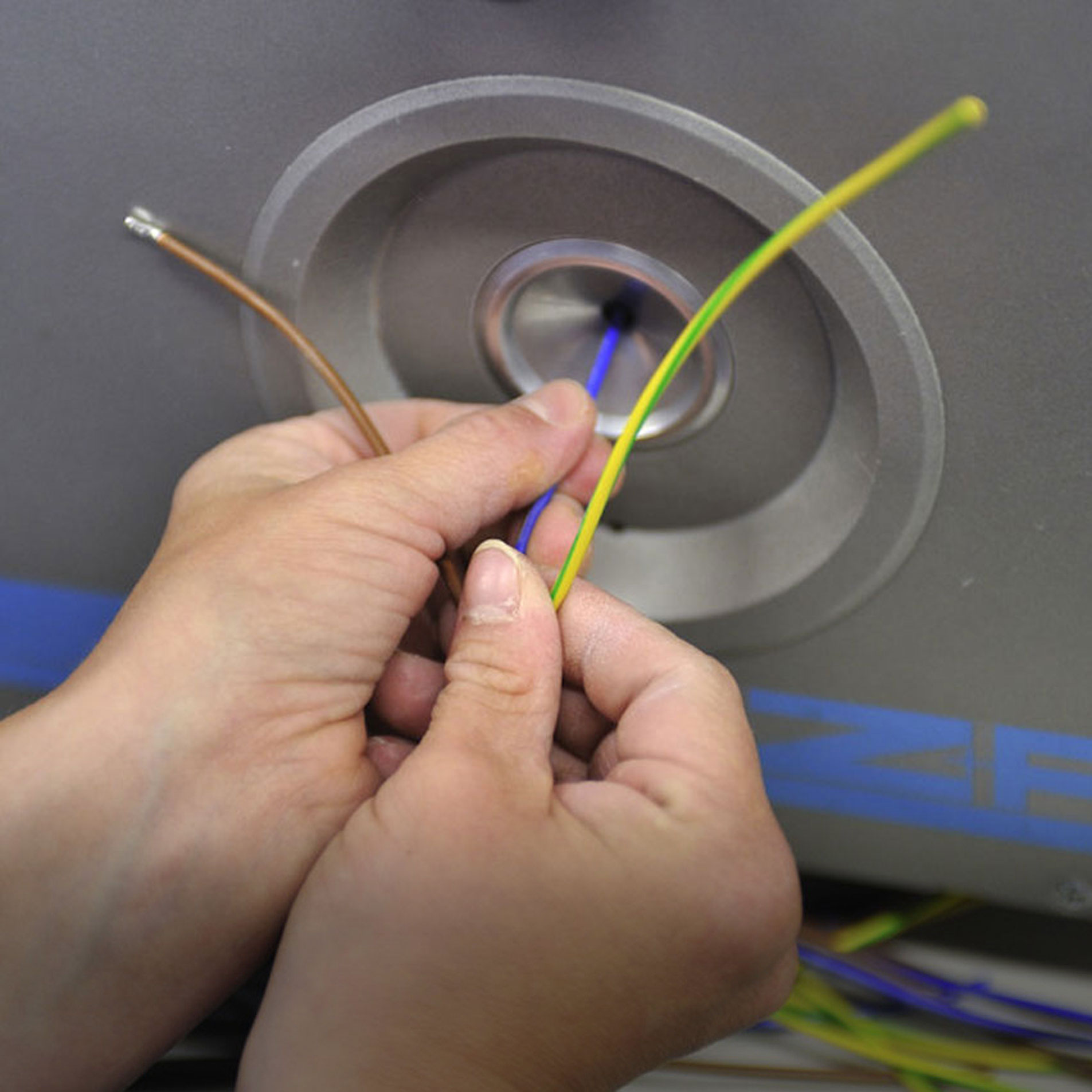 Kabelkonfektionierung Zwei Hände bei der Kabelkonfektionierung