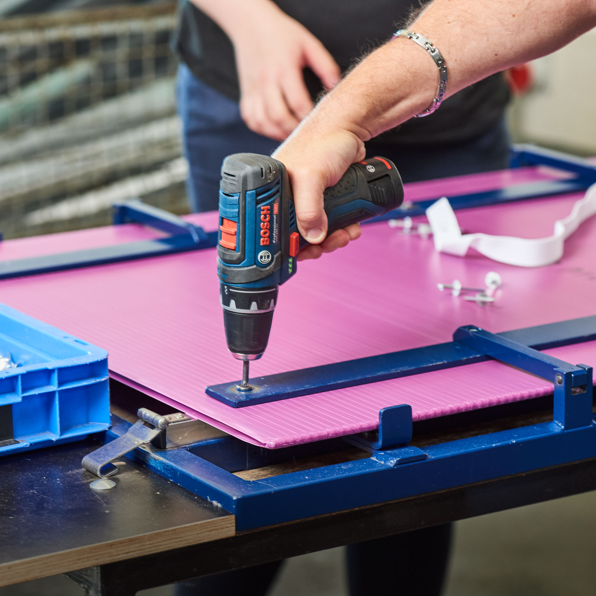 Montage und Verpackung Eine Hand befestigt eine Schraube