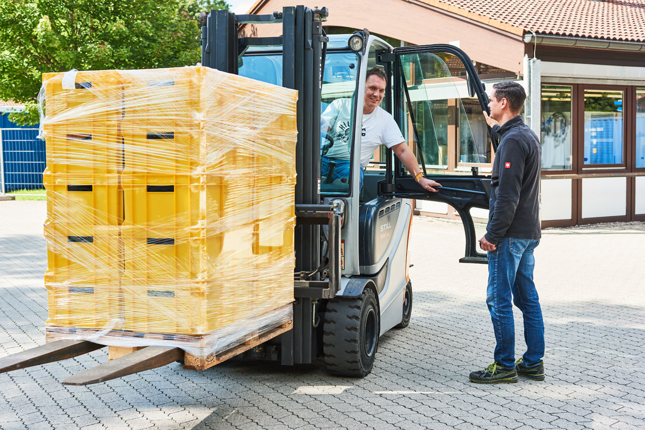 Gabelstapler fahren Ein Klient im Gabelstapler unterhält sich bei geöffneter Tür mit einem Mitarbeiter