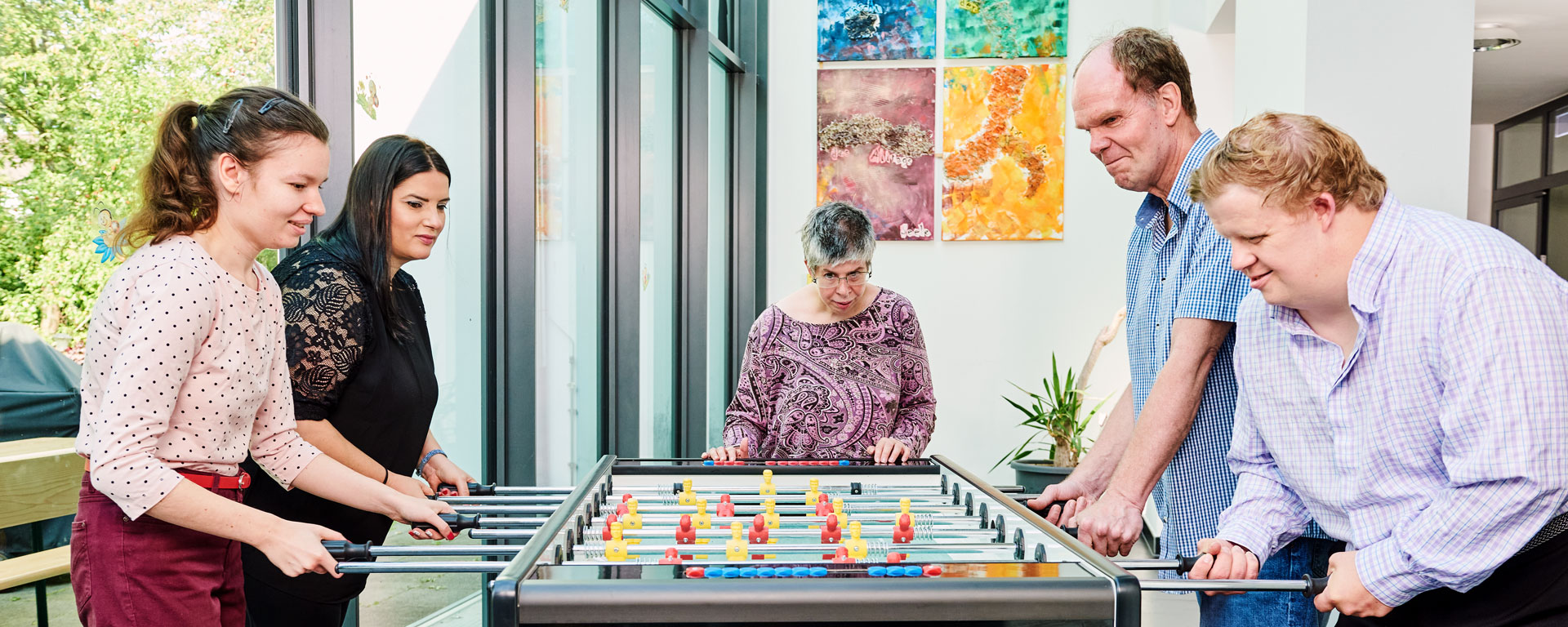 Augustinum Wohnstätten Freizeit Fünf Bewohner*innen der Augustinum Wohnstätten spielen gemeinsam Tischkicker