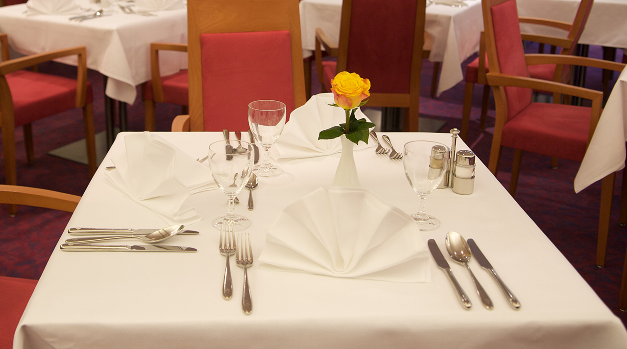 Augustinum Seniorenresidenz Bad Soden Essen Slider Ein gedeckter Tisch mit einer Rose in einer Vase