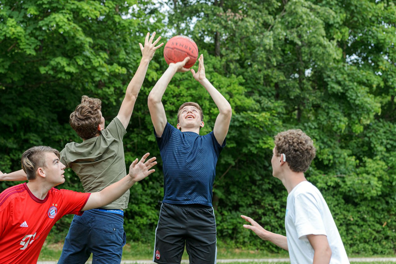 Basketballspielen Eine Gruppe Jugendlicher beim Basketballspielen.