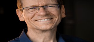 Mann im schwarzem Hemd mit Brille