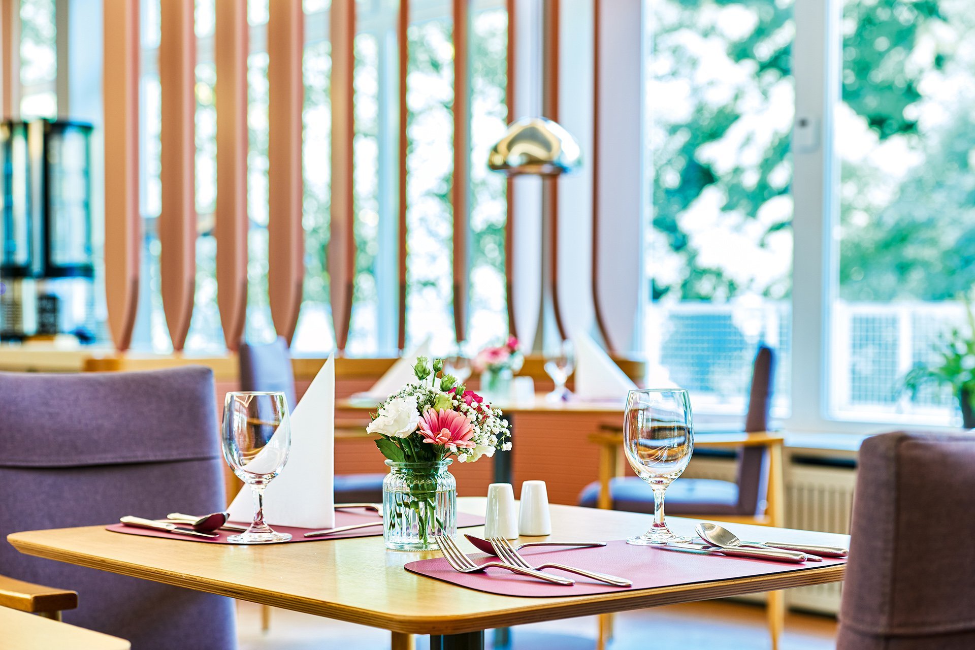 Augustinum Seniorenresidenz Kassel Restaurant Tisch Nahaufnahme eines gedeckten Tisches mit Blumen-Dekoration im Restaurant des Augustinum Kassel