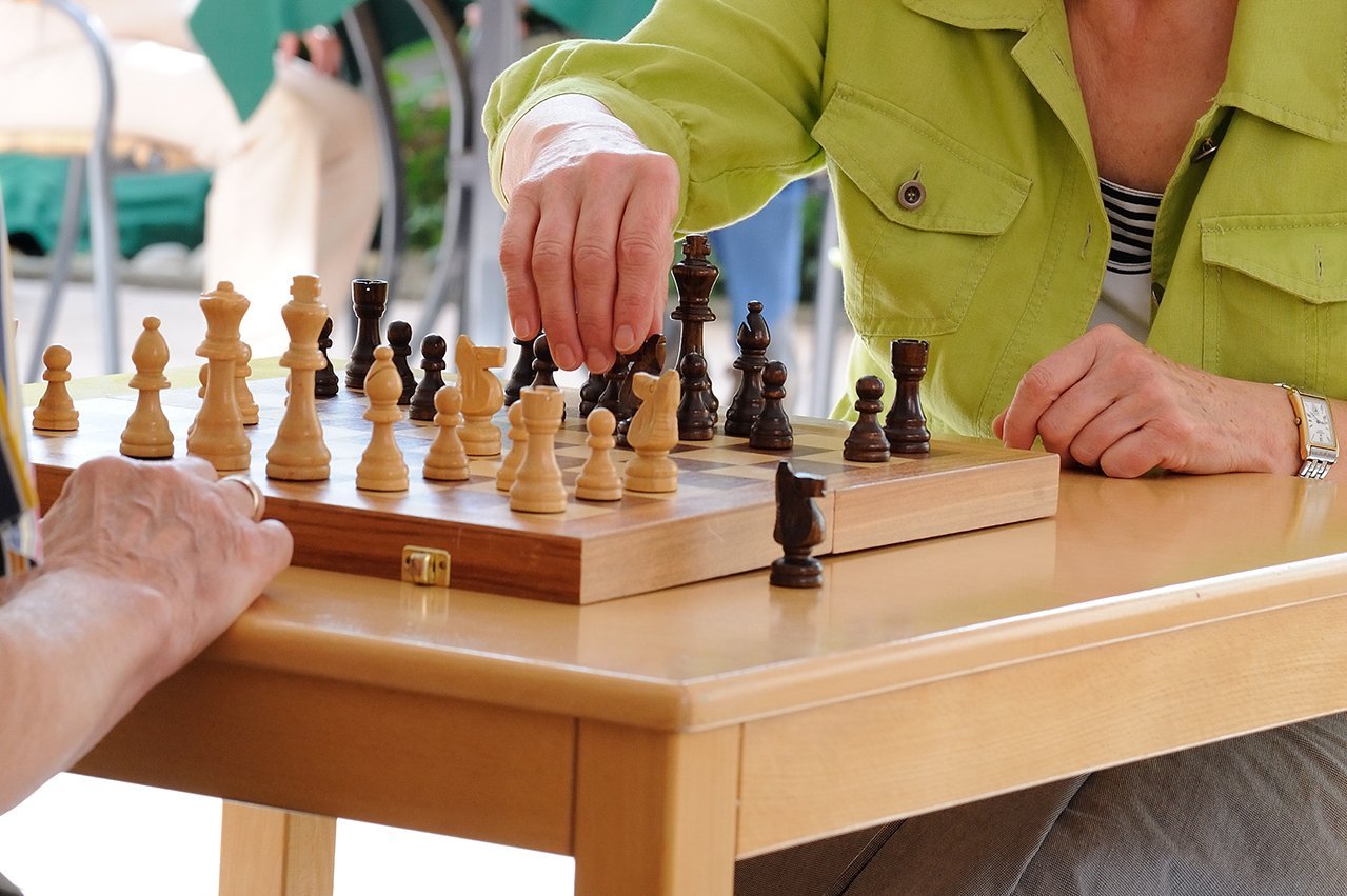 Schach Eine Hand bewegt eine Schachfigur auf dem Schachbrett