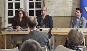 Eine Frau und zwei Männer auf einem Podium im Gespräch