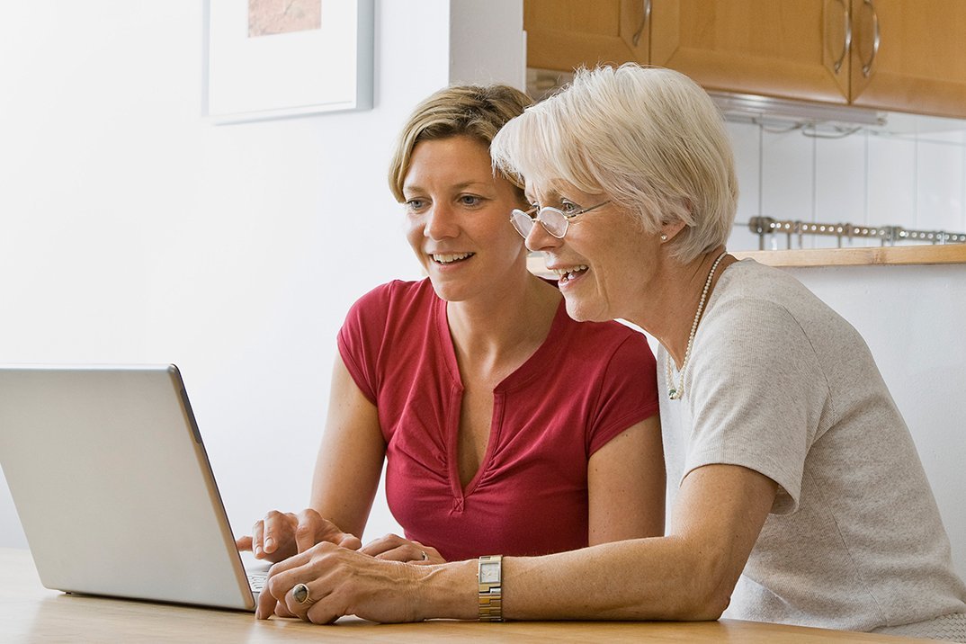 Augustinum Seniorenresidenz Dießen Computerkurs Eine Frau hilft einer Seniorin am Laptop