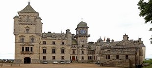 Schottland: Schlösser – Whisky - Dudelsack Historisches Schloss aus hellem Naturstein mit mehreren Türmen, einem Uhrturm und großem Innenhof.