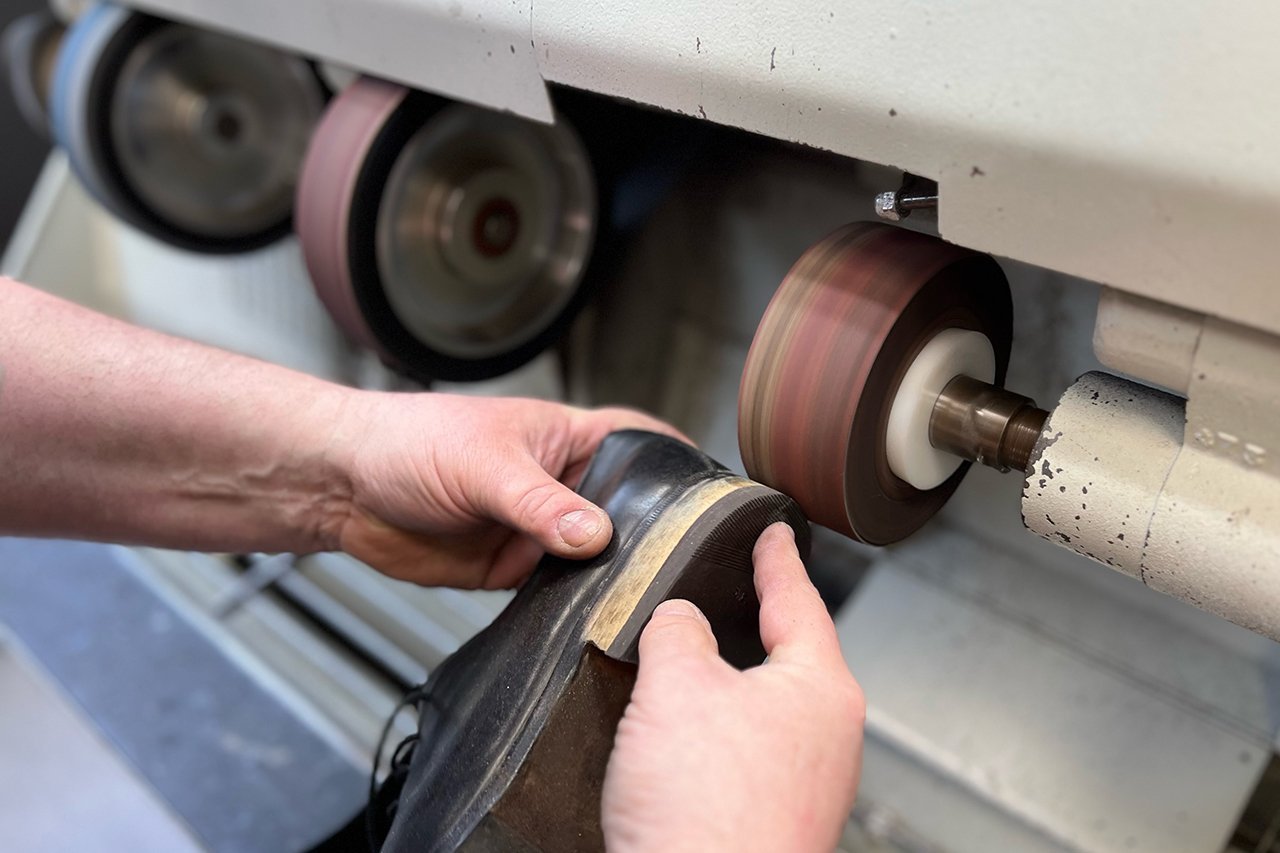 Augustinum Schusterei Schuhreparaturen 2 Die Außenseite eines Schuhabsatzes wird geschliffen