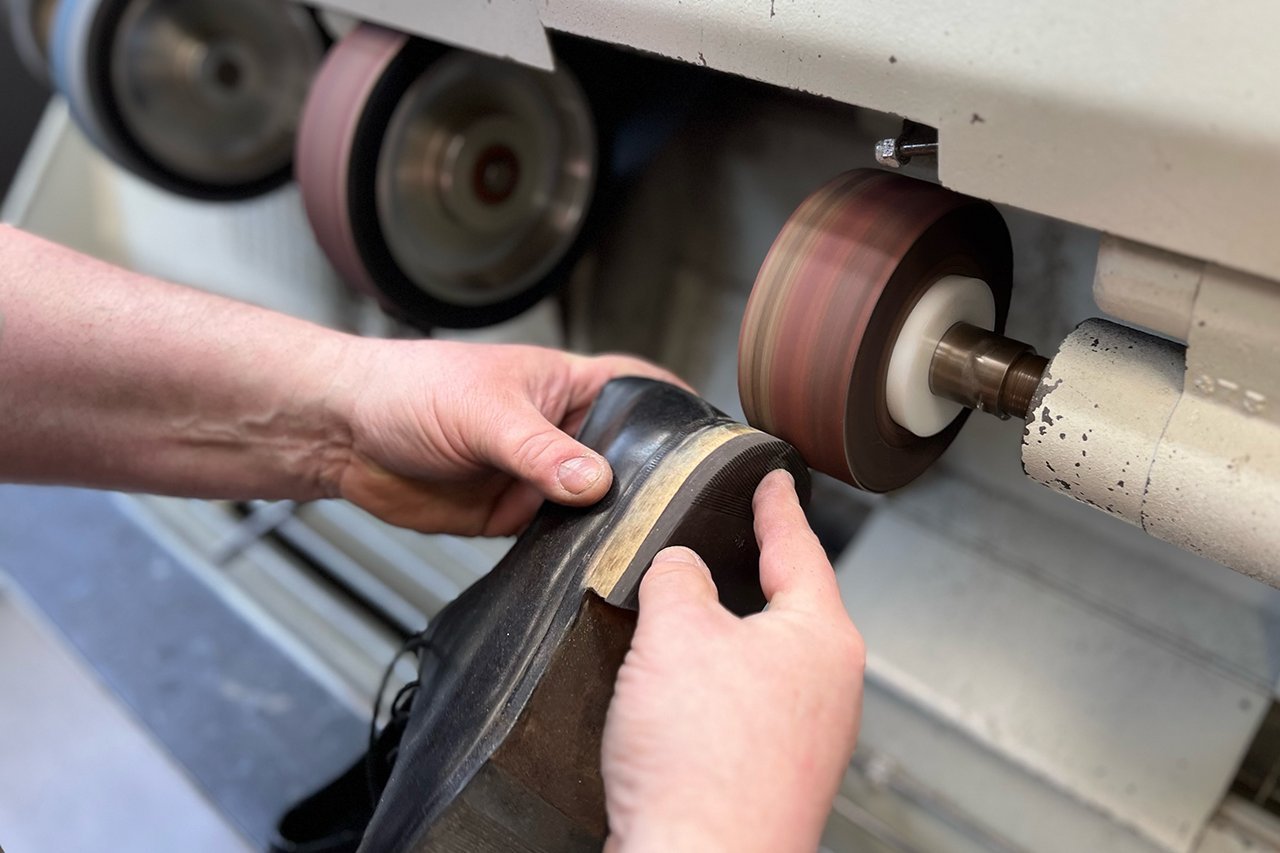 Augustinum Schusterei Schuhreparaturen 2 Die Außenseite eines Schuhabsatzes wird geschliffen